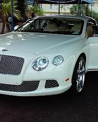 A white Bentley Continental convertible with the door open, washed and dried by hand at the shop.