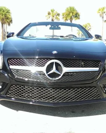 The front of a black Mercedes SL after a full service hand wash, grille and headlights polished clean.